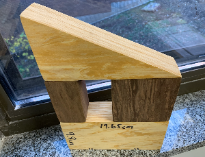 The depth of all solids shown here = 4.5 cm. The shorter leg of the isosceles right triangle (up top) = 9.8 cm. The sides of the square (right) you see are also each 9.8 cm. Another small rectangular prism that's congruent to the one shown on the left wou