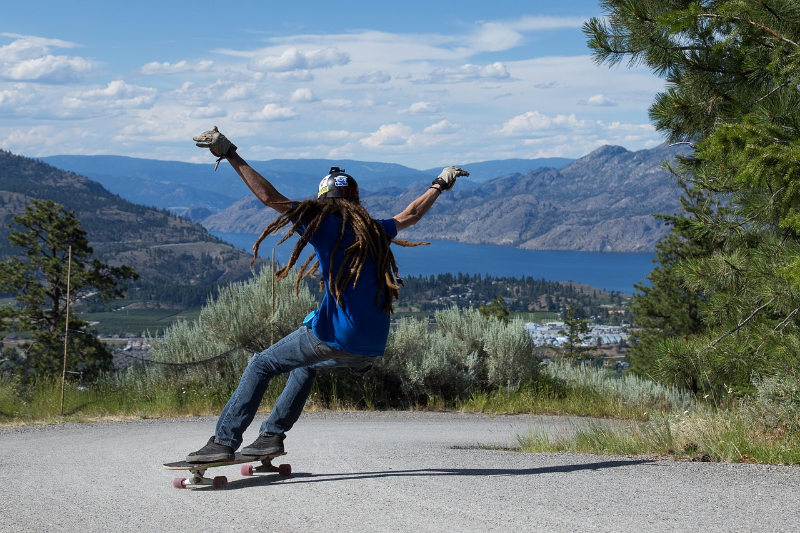 As this skater descends the mountain road some of the gravitational potential energy is converted to kinetic energy.  The rest is lost to dissipative forces like air drag and friction.